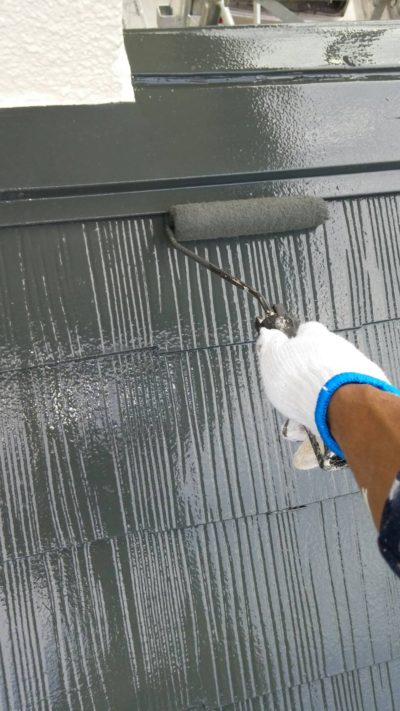 藤沢市K様邸で屋根の仕上げ塗装をローラーで塗っている写真